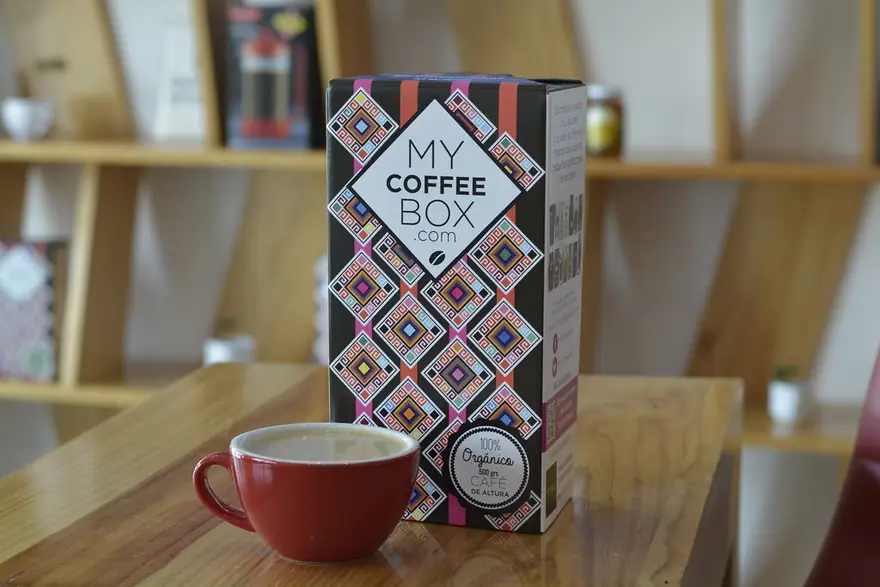 Caja de MyCoffeeBox junto a una taza de café orgánico de Chiapas recién servido